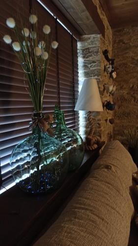 a vase with flowers sitting on a table next to a window at Casa Santiago in Currelos