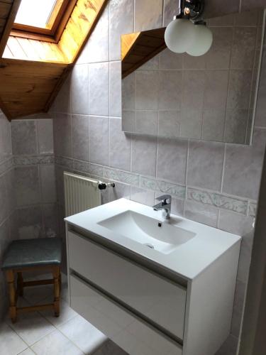 a bathroom with a white sink and a skylight at Pacsirta Apartman in Lenti