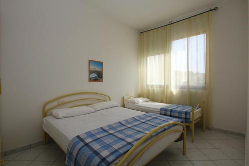 a bedroom with two beds and a window at Acquasmeralda appartamento 03 in Rosolina Mare