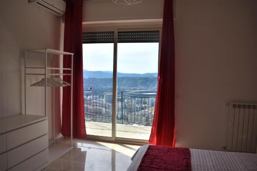 Schlafzimmer mit einem großen Fenster mit roten Vorhängen in der Unterkunft Melograno Home in Neapel