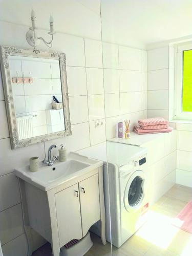 a bathroom with a washing machine and a sink at Romantic Style Apartment Titisee-Neustadt in Titisee-Neustadt