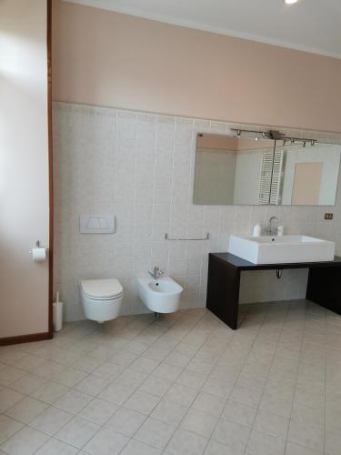 a bathroom with a sink and a toilet and a sink at Il Colibrì Bed&Breakfast in Leno