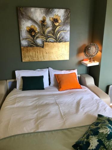 une chambre avec un lit avec un tableau sur le mur dans l'établissement Nid Douillet à Bagatelle, à Deauville