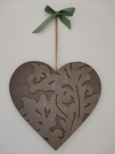 a heart shaped wooden ornament with a green bow at Il Colibrì Bed&Breakfast in Leno