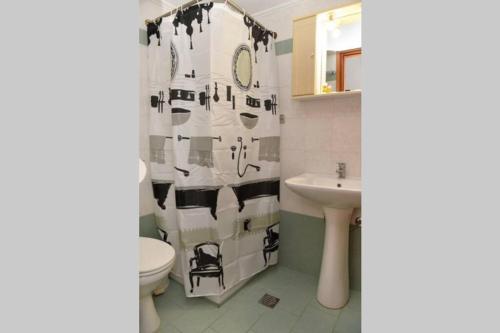 a bathroom with a black and white shower curtain at Atropos Varvara in Posidhonía