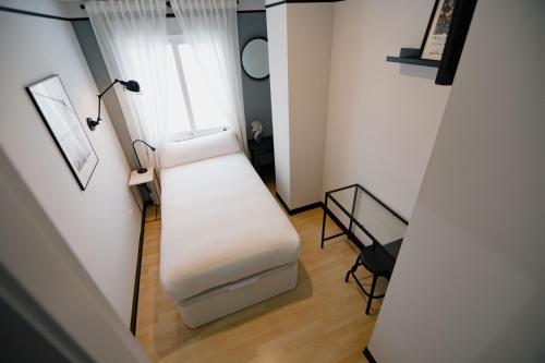 a white bench in a room with a window at The Little Corner B&B in Valencia