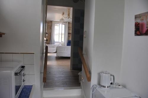 um corredor que leva a uma sala de estar com uma lavandaria em PETITE MAISON des ROSES - GITE 2 Personnes em Brain-sur-Allonnes