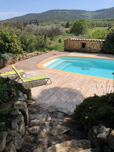 a swimming pool with two lawn chairs next to it at l'Oustaou B&B Piscine & Spa in Besse-sur-Issole