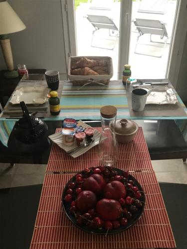 einen Tisch mit einer Schale Obst auf einem Tisch in der Unterkunft La Pépinière in Saint-Sulpice-et-Cameyrac