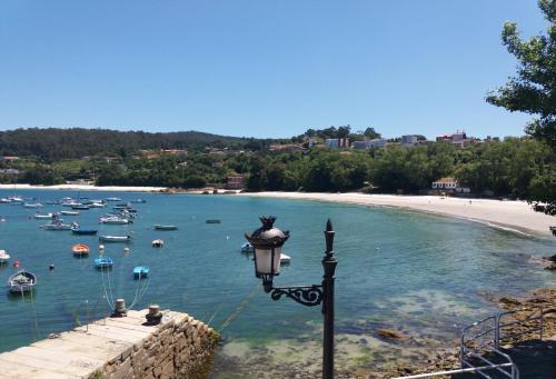 a street light next to a beach with boats in the water at Innmare Fortuna Hotel Dos Estrellas in Marín