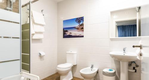 a white bathroom with a toilet and a sink at Innmare Fortuna Hotel Dos Estrellas in Marín