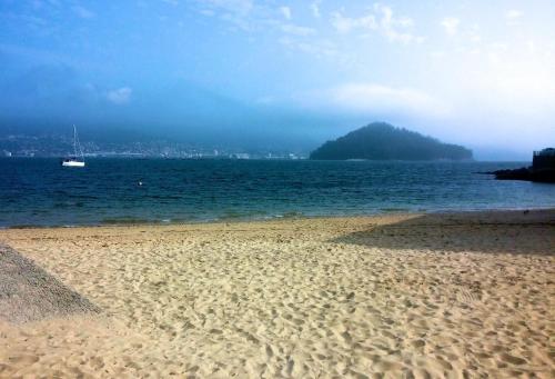 a sandy beach with a boat in the water at Innmare Fortuna Hotel Dos Estrellas in Marín