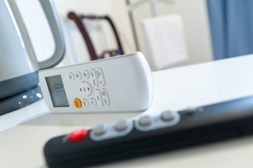 a remote control sitting on a counter next to a microwave at Innmare Fortuna Hotel Dos Estrellas in Marín