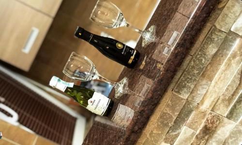 uma garrafa de vinho e copos no balcão em Restoran sa sobama za iznajmljivanje MALI RAJ em Mrkonjic Grad