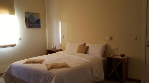 a bedroom with a white bed with two towels on it at La Casa dels Lledoners in Masarach