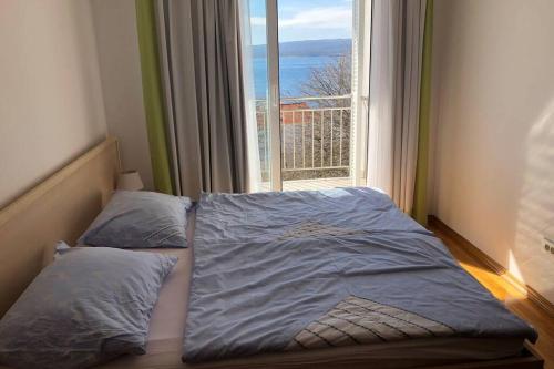 un letto in una camera con una grande finestra di Apartment Jadranka Selce No 64 a Selce
