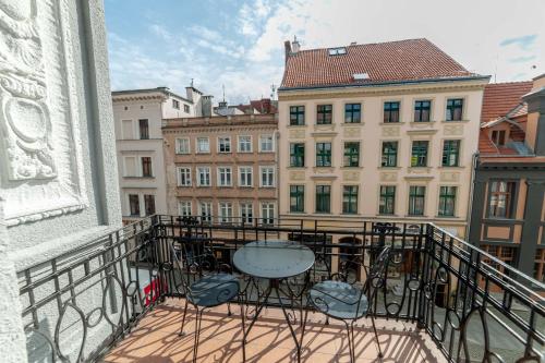 a balcony with a table and chairs and buildings at Apartamenty Street31 in Toruń