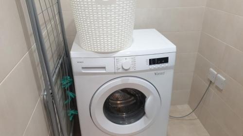 a washing machine with a vase on top of it at Flat 2 Blue Waves in St Paul's Bay