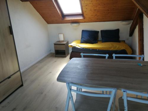 Cette petite chambre comprend une table et un lit. dans l'établissement En mansarde sur le port, à Les Sables-dʼOlonne