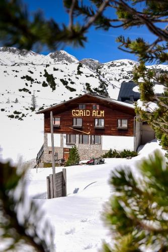 a building with a sign on it in the snow at Gjaid-Alm 1739m am Dachstein-Only Accessible by Cable Car in Obertraun