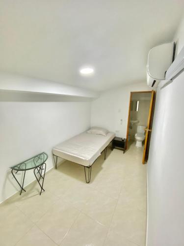 a small room with a bed and a table at La Casona 42 in Barranquilla