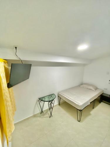 a small room with a bed and a table at La Casona 42 in Barranquilla