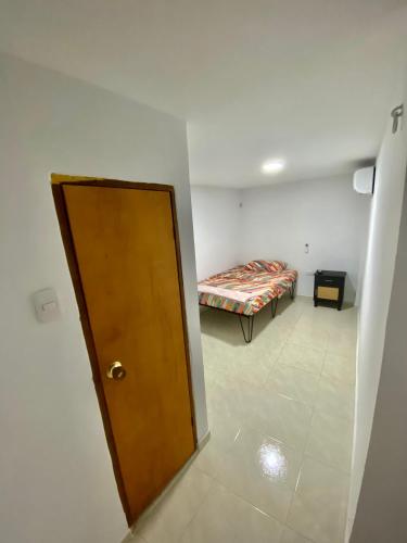 a room with a bed and a wooden door at La Casona 42 in Barranquilla