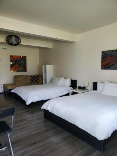 a hotel room with two beds and a couch at Orange Bistro in Baie-Saint-Paul