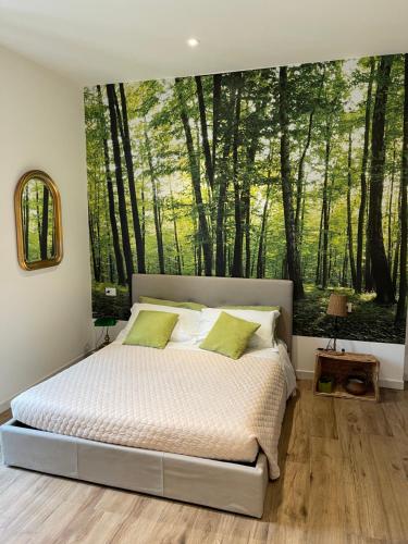 una camera da letto con un letto dipinto di alberi di Green Appartamenti i Portici nel centro storico a Melzo