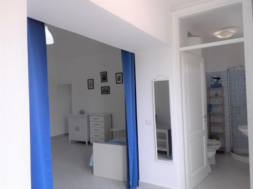 a white bathroom with a blue mirror and a sink at da Letizia in Procida