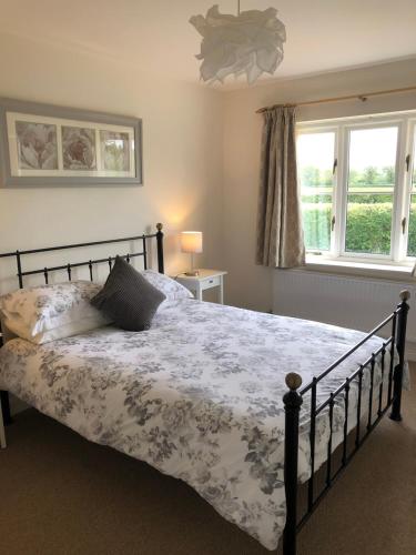 a bedroom with a bed and a window at Wisteria Cottages are self catering cottages in a beautiful village location in Dorrington