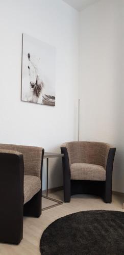 a living room with two chairs and a rug at HB 32 Metzingen in Metzingen