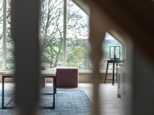 a room with a large window with a table and a chair at Walton House Cottage in Chapel en le Frith