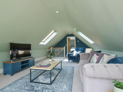 a living room with a couch and a tv at Walton House Cottage in Chapel en le Frith