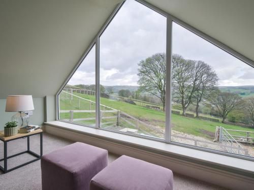 a room with a large window with a view of a field at Walton House Cottage in Chapel en le Frith