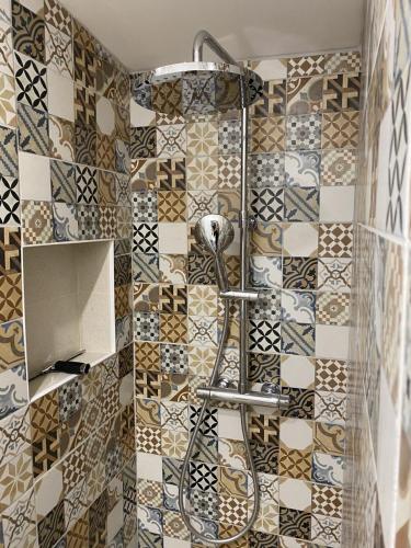 La salle de bains est pourvue d'une douche et de carrelage sur le mur. dans l'établissement L'échappée Bordelaise, à Portets