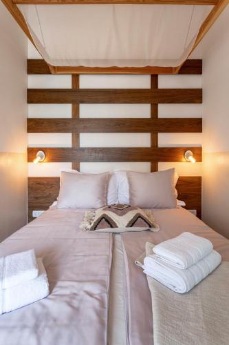 a bed with white sheets and towels on it at NORMABEL relaxing villa with heated pool and sauna in Žrnovnica