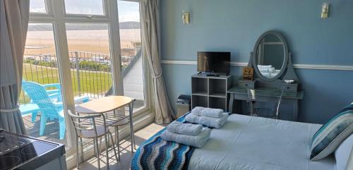 a bedroom with a bed and a view of the beach at The Sunfold in Weston-super-Mare
