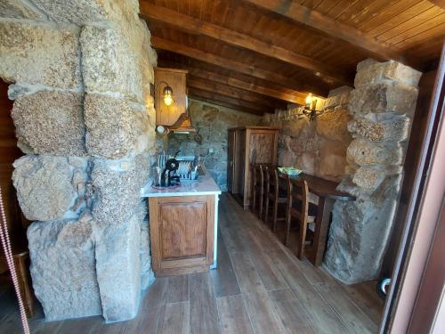 a room with a counter and a stone wall at Casa Guardião do Castelo in Celorico de Basto