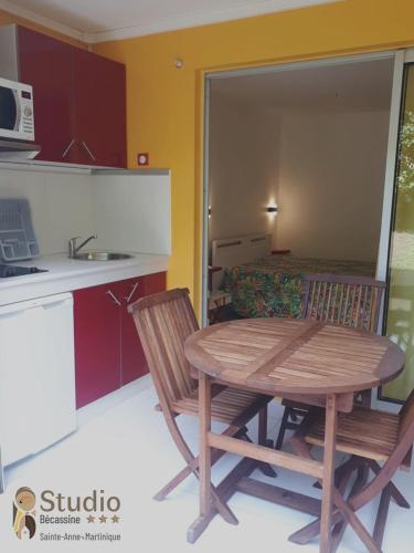 a kitchen with a table and two chairs and a table at Studios Becassine et Tangara Domaine de Belfond St Anne in Sainte-Anne