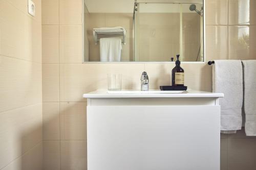 a bathroom with a white sink and a mirror at Casas Sul in Burgau