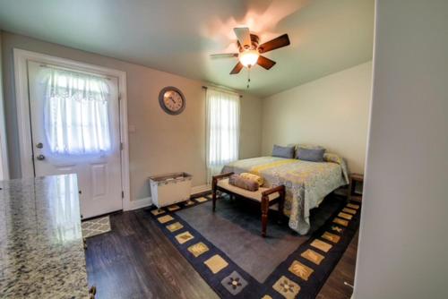 - une chambre avec un lit et un ventilateur de plafond dans l'établissement Historic Town Square Bungalow in heart of Brighton, à Atoka