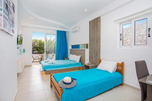 een hotelkamer met 2 bedden en een balkon bij Stay Helios in Faliraki