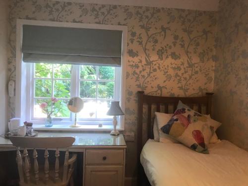 a bedroom with a bed and a window at West Lodge Hotel in Aylesbury
