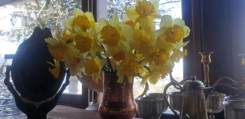 a bunch of yellow flowers in a vase on a table at Traditional Rooms karaouli in Papigko