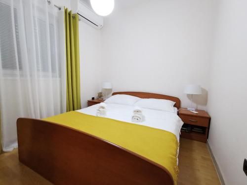 a bedroom with a bed with a yellow and white blanket at Villa Dea in Kotor