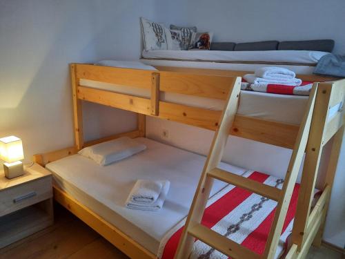 two bunk beds in a small room with a lamp at Kuća Get in Betina