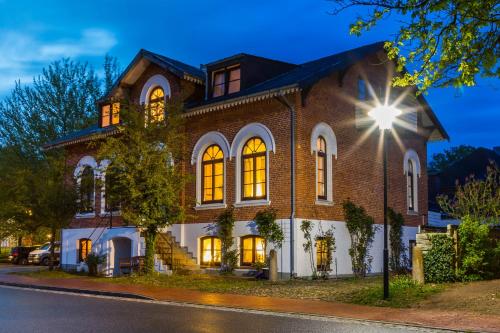 テニングにあるSmukkegård - historisch Wohnen im modernen Ambienteの灯り付きの大きなレンガ造りの家