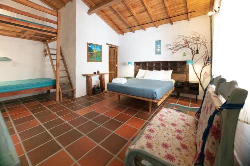 ein Schlafzimmer mit einem Bett und einer Leiter und einer Couch in der Unterkunft Finca La Colina De Los Azulejos in Guadalupe