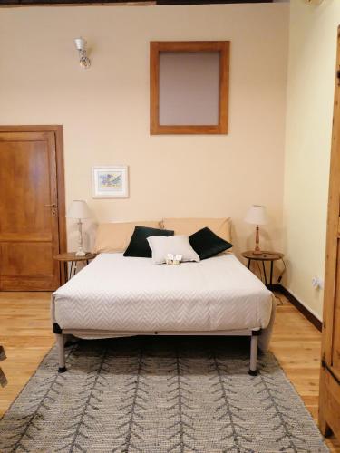 a bedroom with a white bed with two tables at la casetta in Sassari